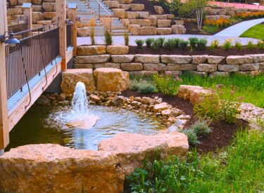 Boulder retaining wall, steps bridge and pond